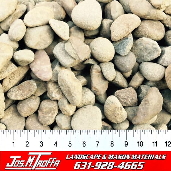 Assorted small pebbles in various shapes and colors shown with a ruler for scale, from JOS. M. TROFFA Landscape & Mason Materials in Long Island, NY.