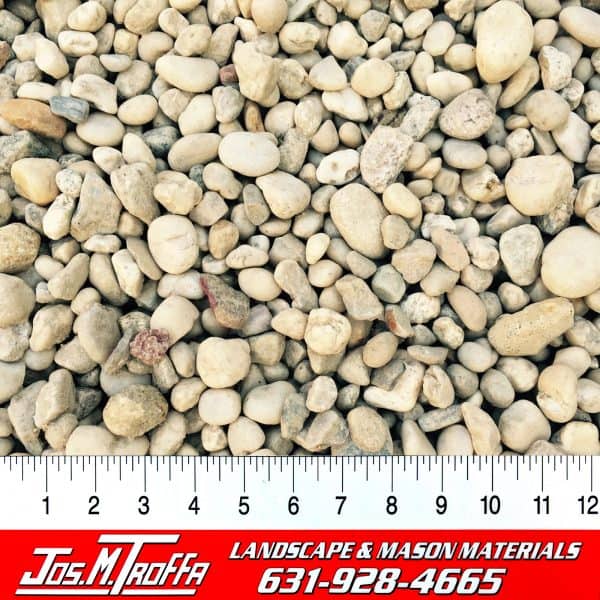 Assorted small pebbles in various shapes and colors shown with a ruler for scale, from JOS. M. TROFFA Landscape & Mason Materials in Long Island, NY.