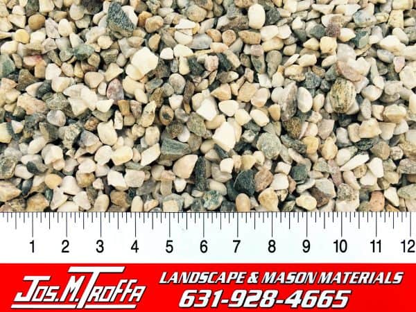 Assorted small pebbles in various shapes and colors shown with a ruler for scale, from JOS. M. TROFFA Landscape & Mason Materials in Long Island, NY.