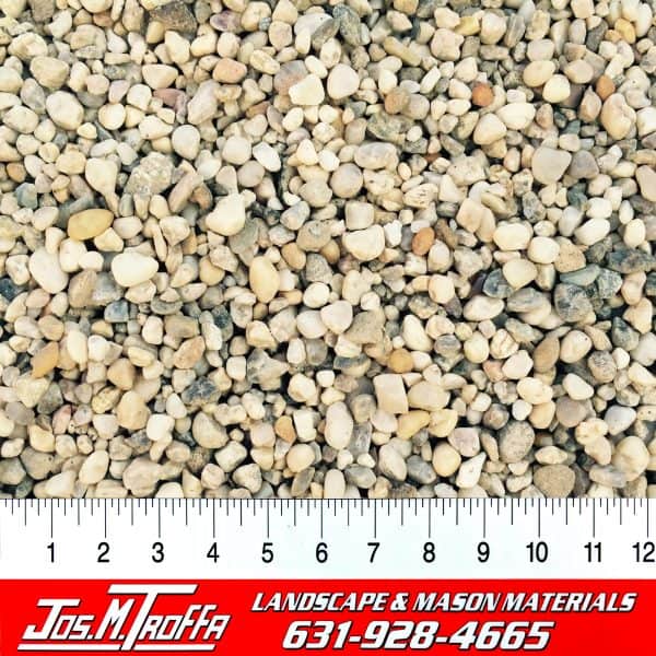 Assorted small pebbles in various shapes and colors shown with a ruler for scale, from JOS. M. TROFFA Landscape & Mason Materials in Long Island, NY.