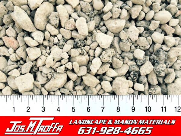 Smooth, rounded pebbles in varying shades of gray shown with a ruler for scale, from Jos. M. Troffa Landscape & Mason Materials in Long Island, NY