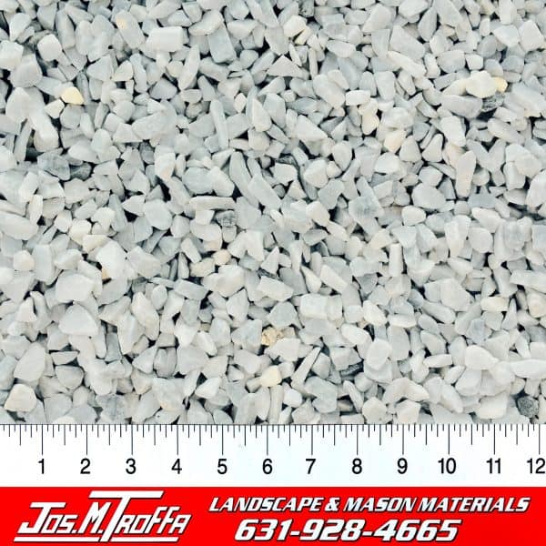 Light-colored gravel stones displayed with a ruler for size reference, from JOS. M. TROFFA Landscape & Mason Materials in Long Island, NY.