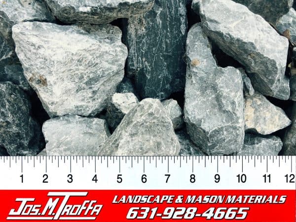 Gray landscape rocks of various sizes shown with a ruler for scale, from JOS. M. TROFFA Landscape & Mason Materials in Long Island, NY