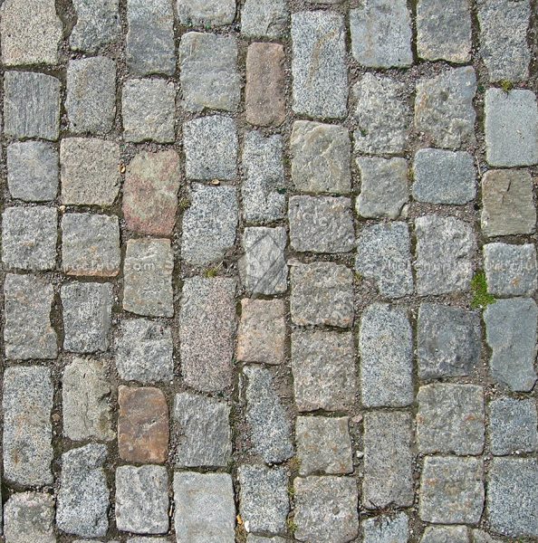 Cobblestone pavement in Long Island, NY featuring rectangular stones in varying shades of gray, brown, and red arranged in a staggered pattern.