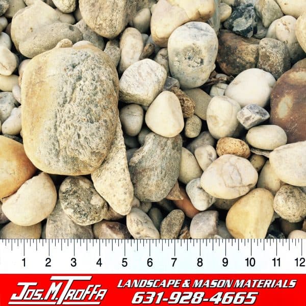 Assorted landscape rocks and pebbles in various colors and sizes displayed with a ruler for scale, from JOS. M. TROFFA Landscape & Mason Materials in Long Island, NY.